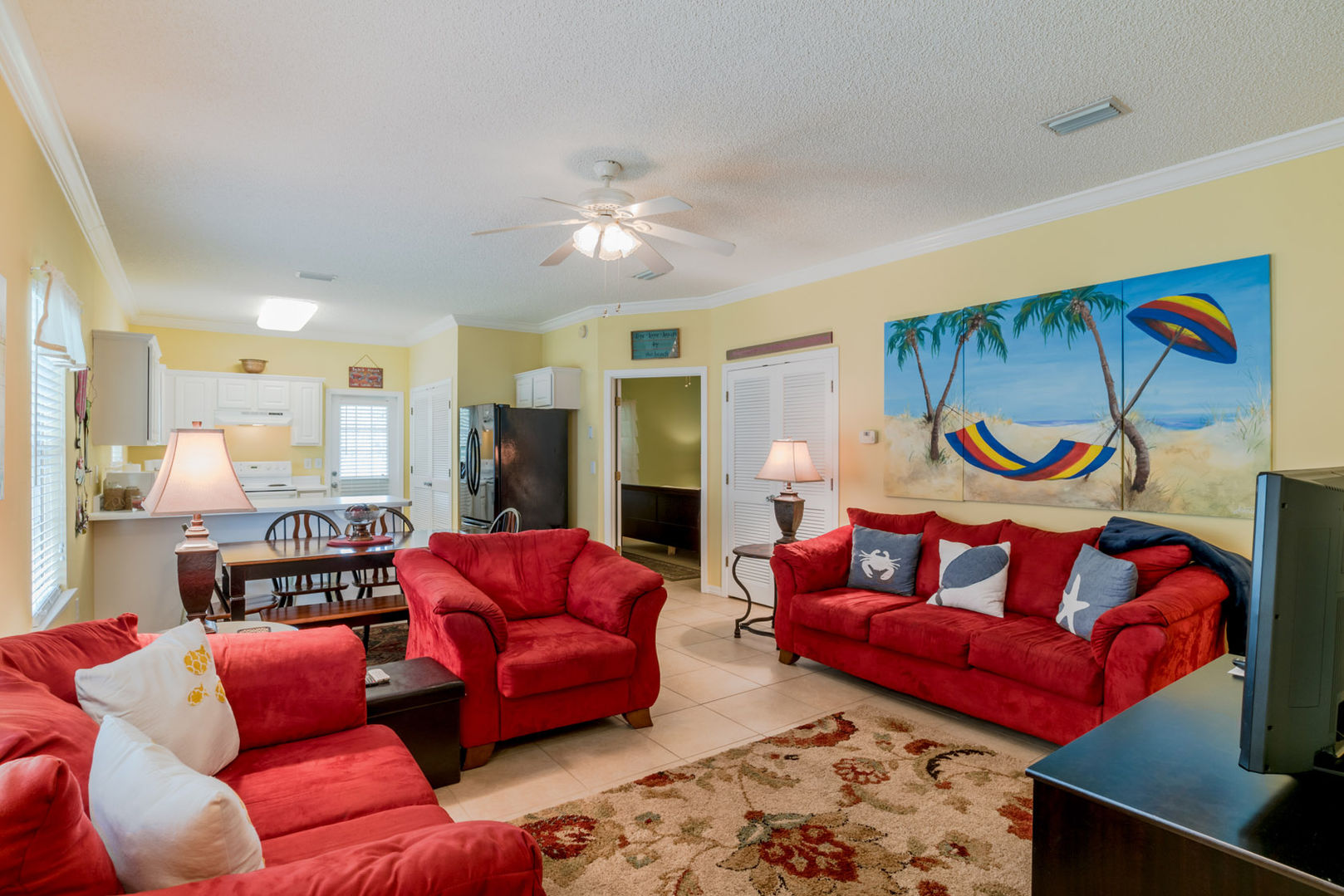 spacious living room in our vacation rentals in Ft Morgan Alabama with red couch and armchair